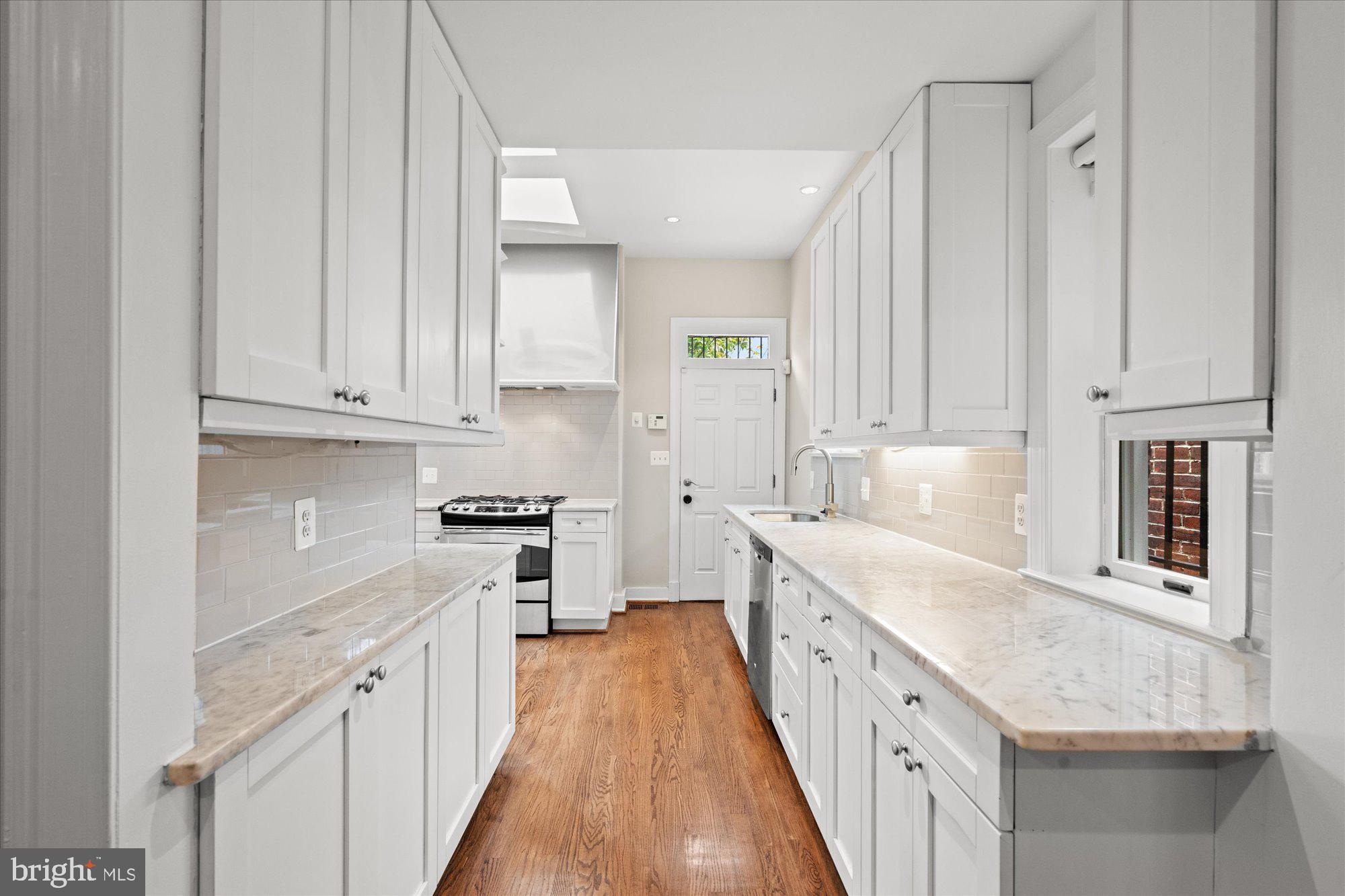 1209 S Street Northwest Washington, DC 20009 - Photo 13 of 64 a kitchen with granite countertop white cabinets and white appliances
