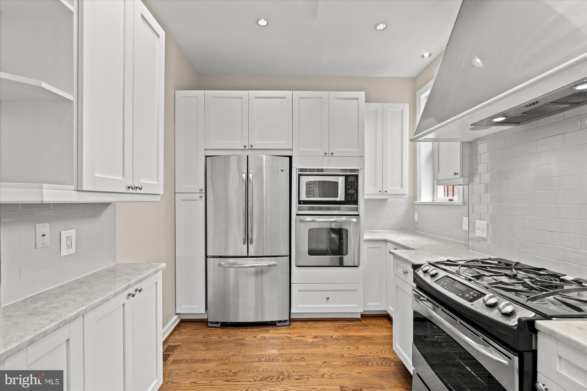 1209 S Street Northwest Washington, DC 20009 - Photo 15 of 64 a kitchen with white cabinets and stainless steel appliances