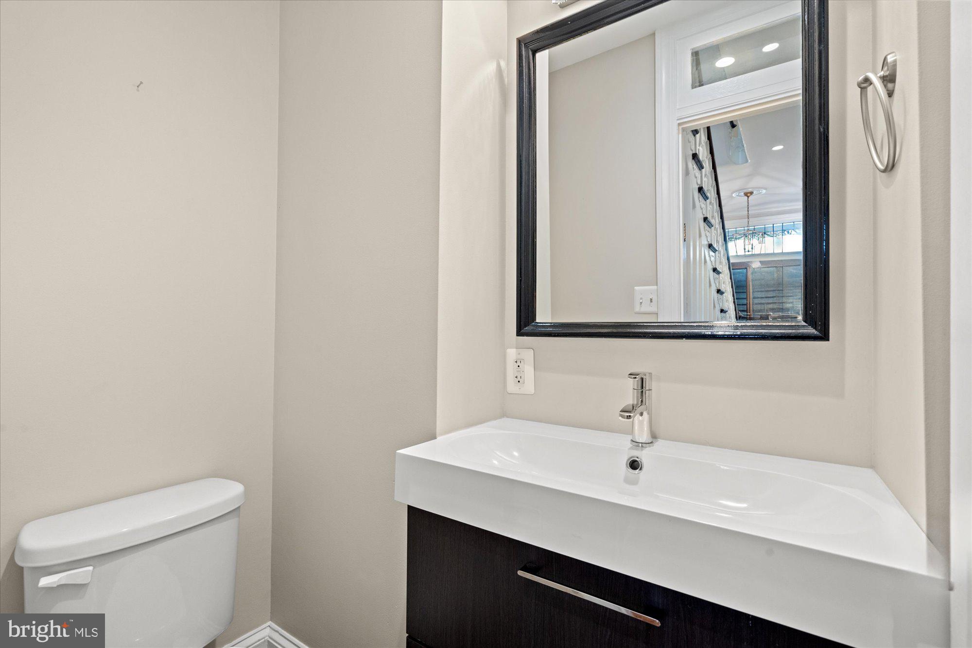 1209 S Street Northwest Washington, DC 20009 - Photo 18 of 64 a bathroom with a toilet a sink and mirror