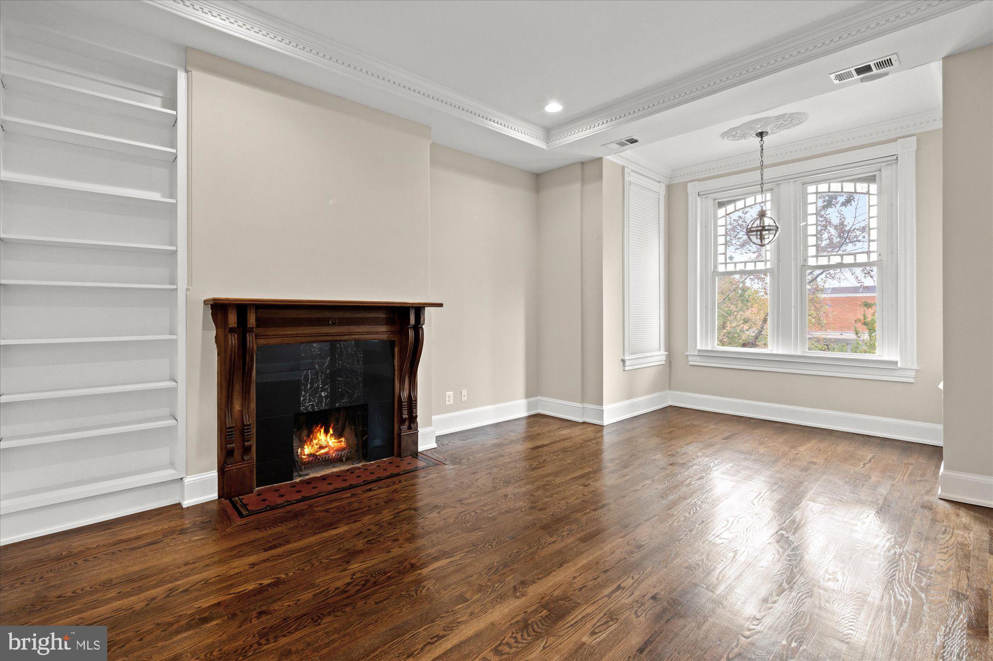 1209 S Street Northwest Washington, DC 20009 - Photo 19 of 64 a view of an empty room with wooden floor fireplace and a window