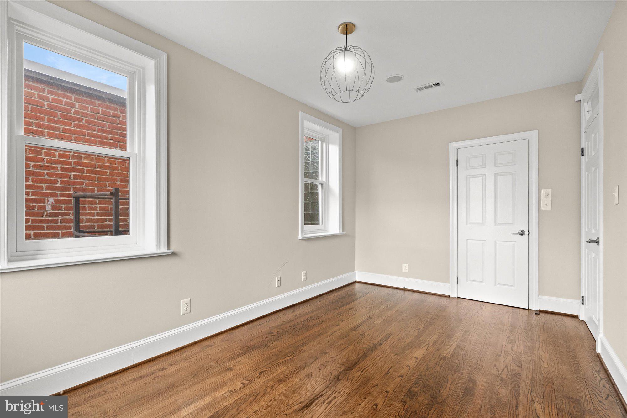1209 S Street Northwest Washington, DC 20009 - Photo 25 of 64 a view of an empty room with wooden floor and a window