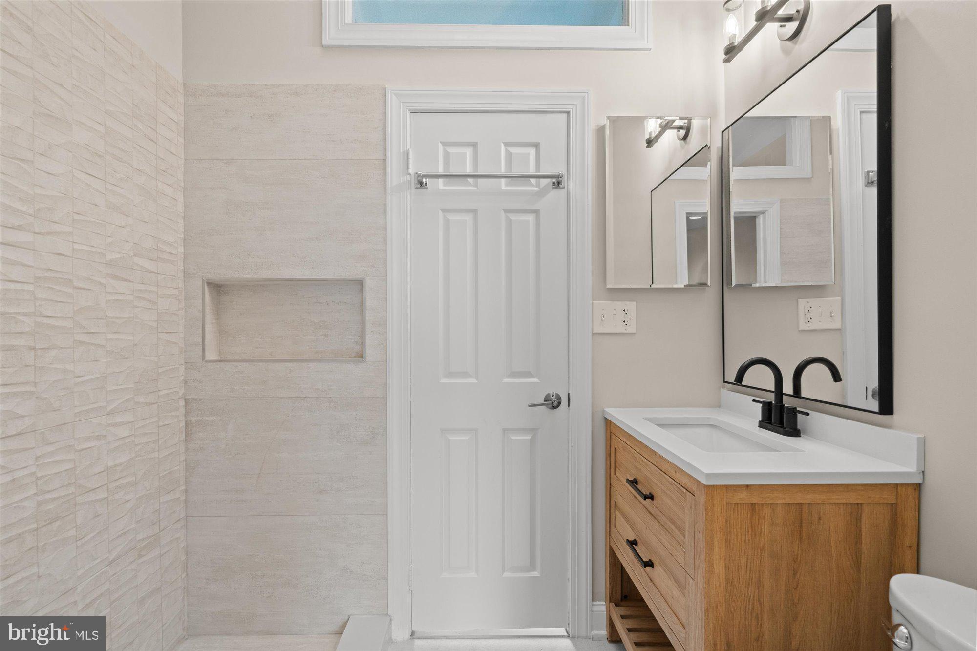 1209 S Street Northwest Washington, DC 20009 - Photo 34 of 64 a bathroom with a sink a mirror and shower