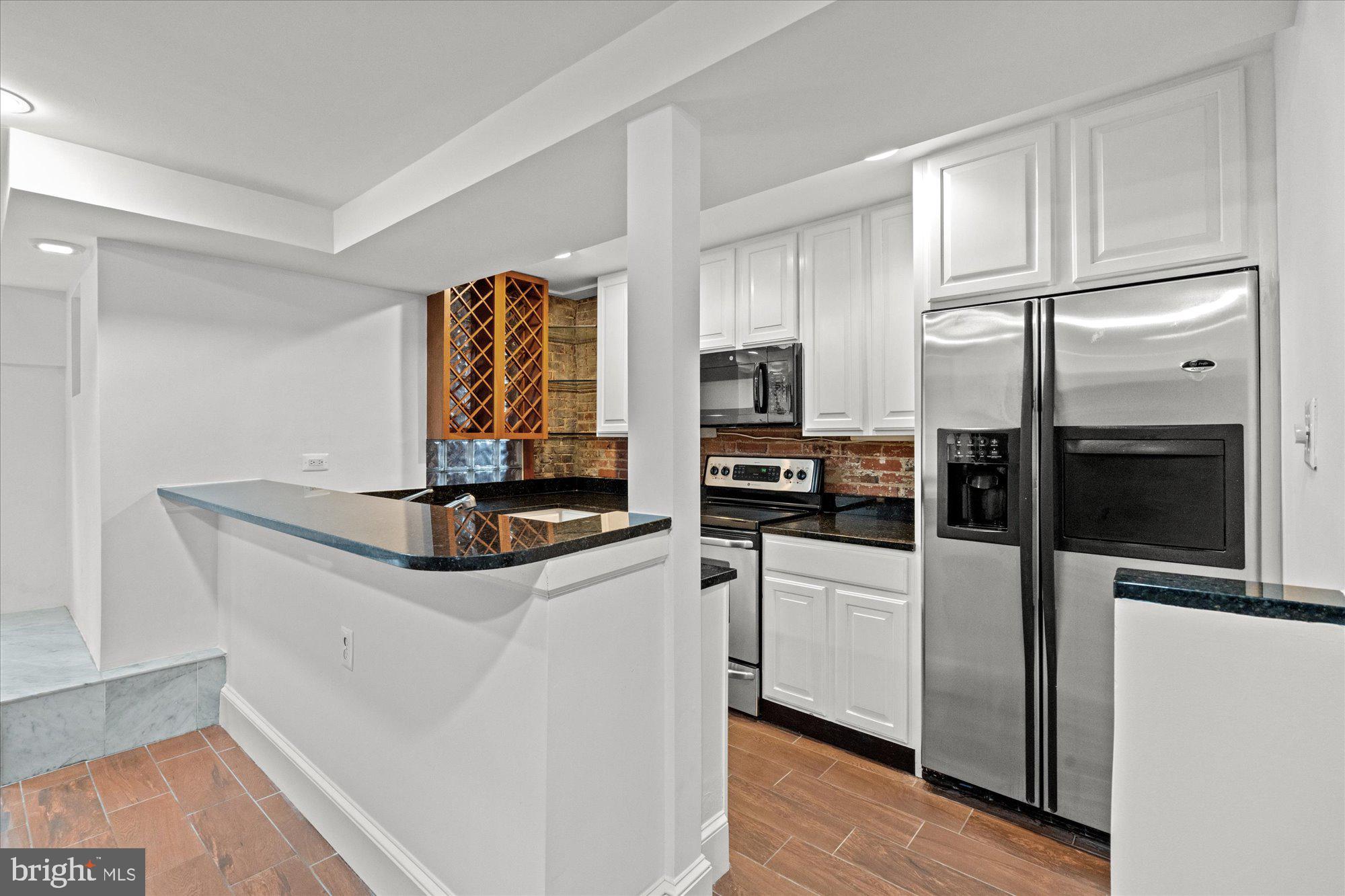 1209 S Street Northwest Washington, DC 20009 - Photo 47 of 64 a kitchen with stainless steel appliances a microwave a stove and refrigerator