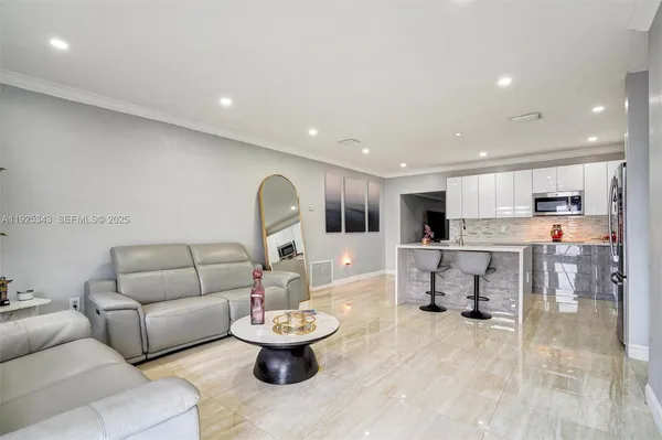a living room with furniture and view of kitchen