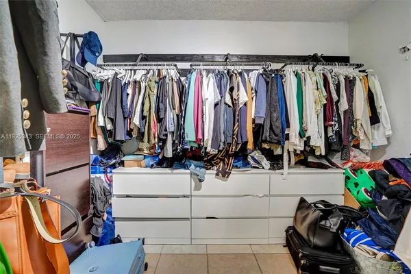 a view of walk in closet with clothes and shoes