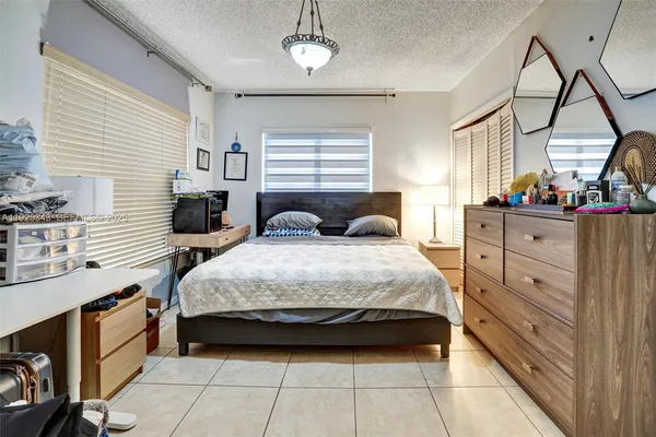 a bedroom with a bed a dresser and mirror