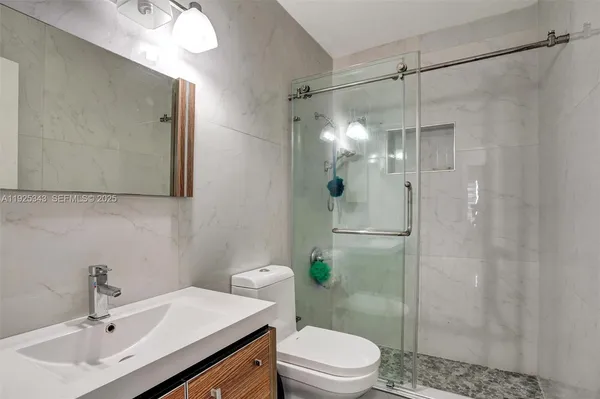 a bathroom with a sink a toilet and shower