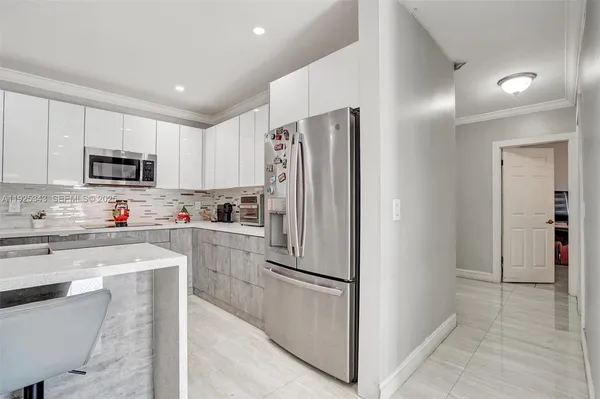 a kitchen with white cabinets and stainless steel appliances