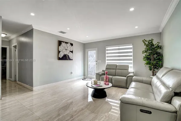 a living room with furniture and a potted plant