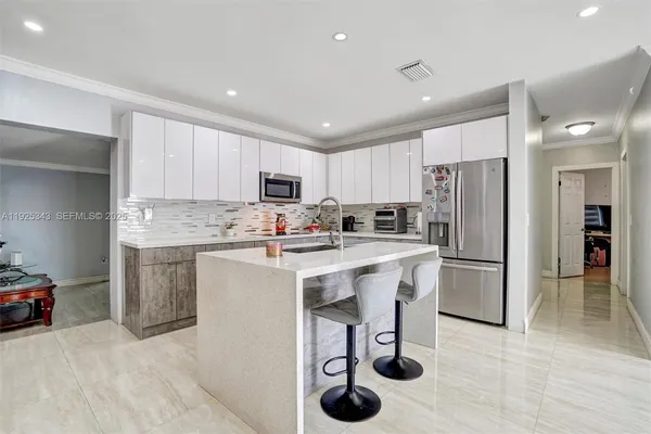 a kitchen with a refrigerator a sink and cabinets