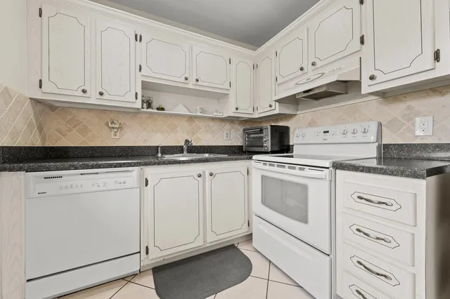 a kitchen with white cabinets and white appliances