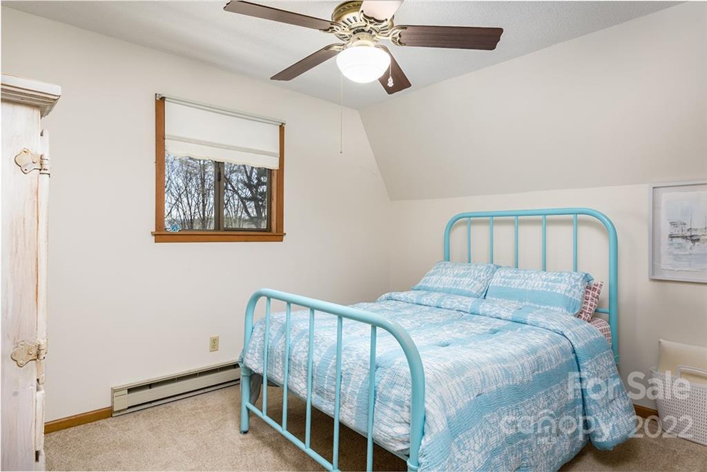 20 Lady Slipper Loop Newland, NC 28657 - Photo 27 of 44 a bedroom with a bed and a chandelier