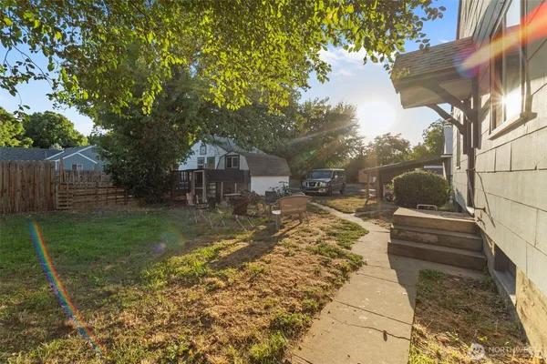 a view of a yard with plants and a bench