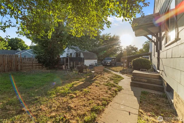 a view of a yard with plants and a bench