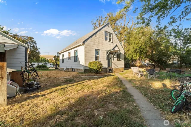 a view of a house with backyard and sitting area