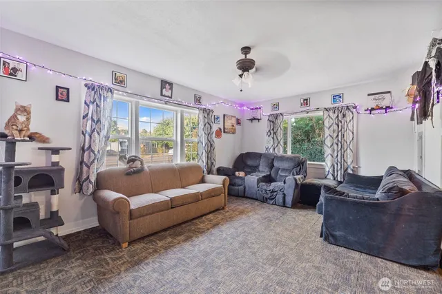 a living room with furniture flat screen tv and a large window