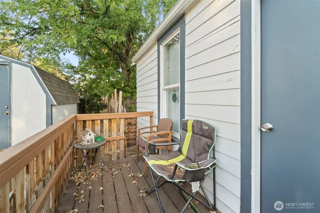 a balcony with wooden floor and outdoor seating
