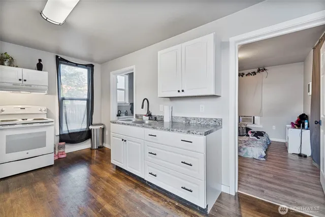 a kitchen with granite countertop white cabinets and white appliances