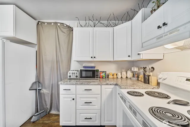 a kitchen with granite countertop a sink stove and cabinets