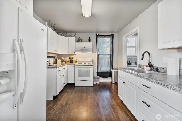 a kitchen with white cabinets and white appliances