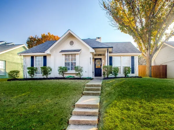 a front view of a house with a yard and green space