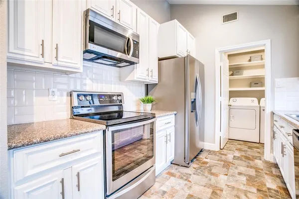 a kitchen with stainless steel appliances granite countertop a stove microwave and refrigerator