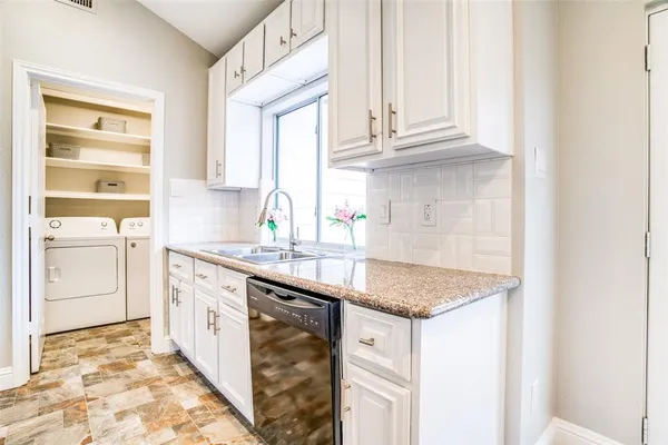 a kitchen with granite countertop a sink stainless steel appliances and cabinets