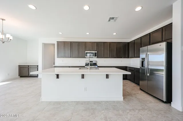 a view of kitchen with stainless steel appliances granite countertop a stove a refrigerator a sink and a microwave