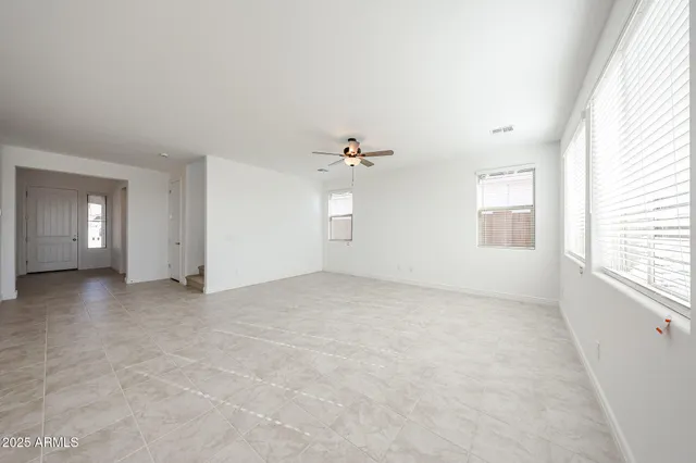 an empty room with windows and cabinet