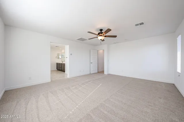a view of an empty room with a chandelier fan