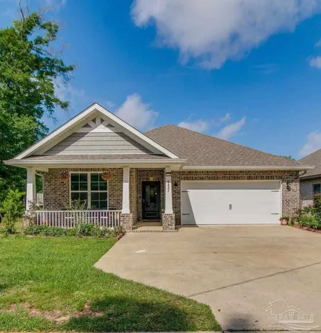 a front view of a house with a garden and yard