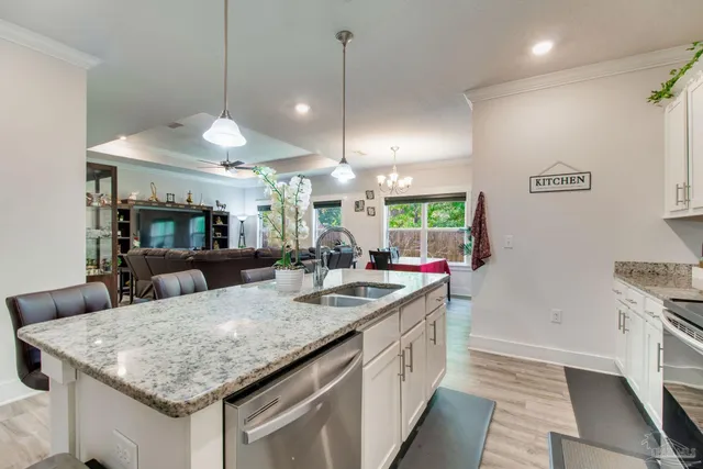 a kitchen with granite countertop a sink a counter top space and stainless steel appliances