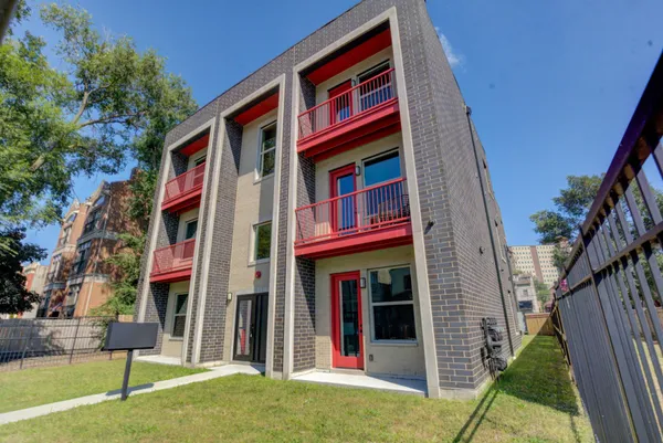 a front view of a multi story residential apartment building with yard