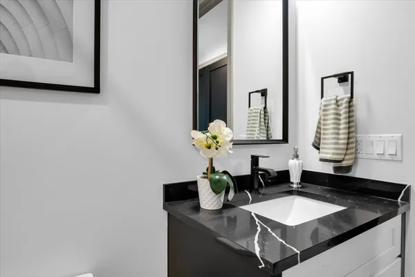 a bathroom with a granite countertop sink and a mirror