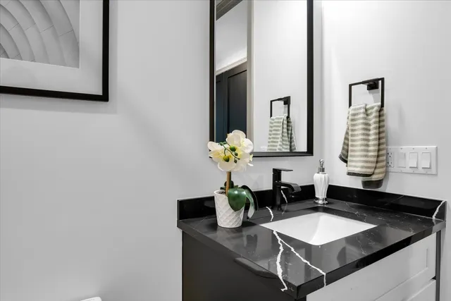 a bathroom with a granite countertop sink and a mirror
