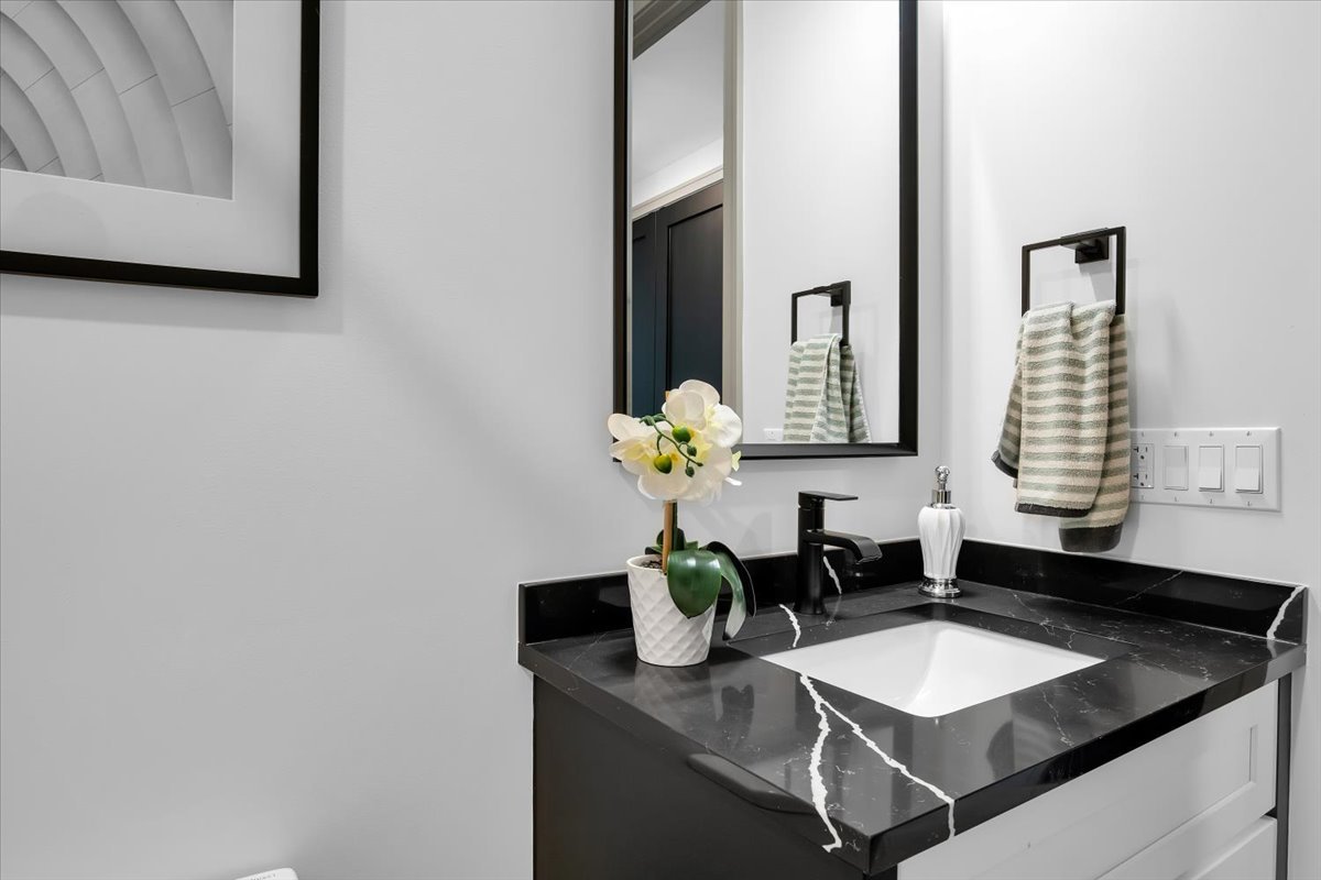 4235 South Champlain Avenue, Unit 1N Chicago, IL 60653 - Photo 20 of 26 a bathroom with a granite countertop sink and a mirror