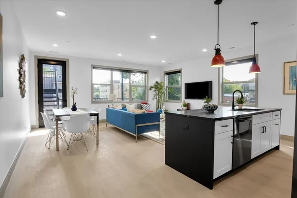 a view of living room kitchen with stainless steel appliances granite countertop couches a flat screen tv
