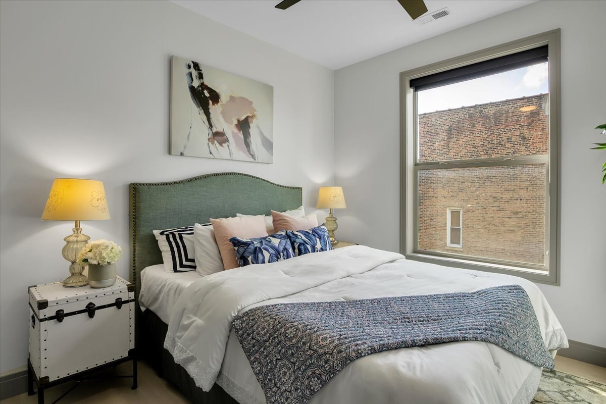 4235 South Champlain Avenue, Unit 1N Chicago, IL 60653 - Photo 22 of 26 a bedroom with a bed and window