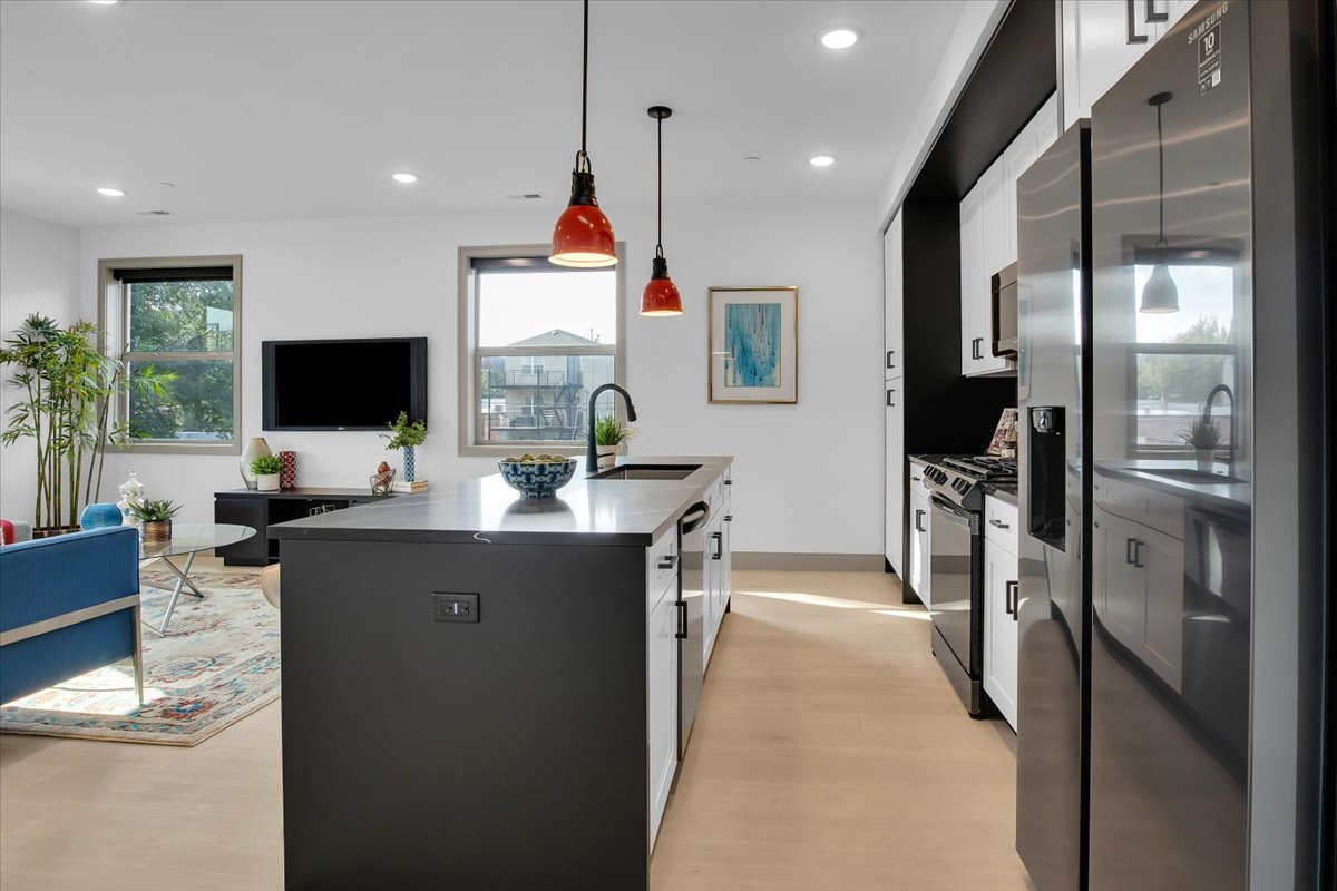 4235 South Champlain Avenue, Unit 1N Chicago, IL 60653 - Photo 6 of 26 a kitchen with stainless steel appliances kitchen island granite countertop a refrigerator and a sink