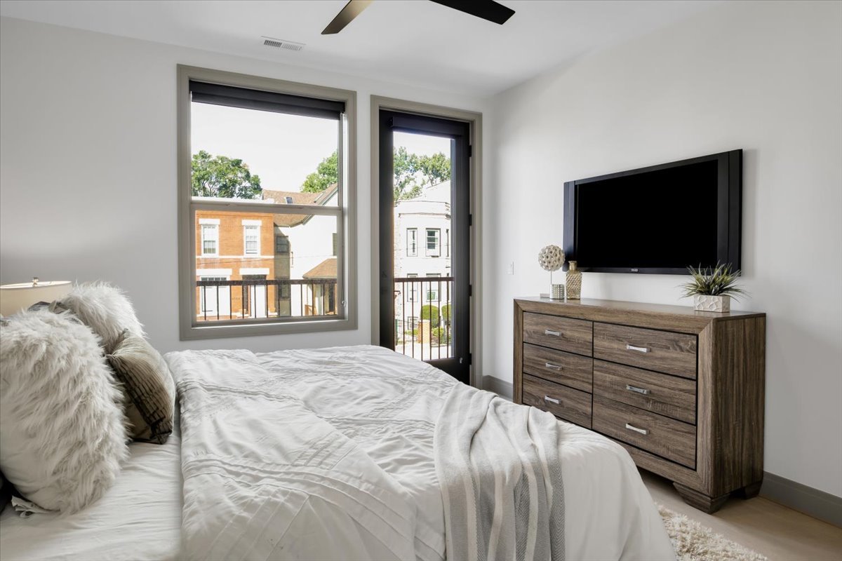 4235 South Champlain Avenue, Unit 1N Chicago, IL 60653 - Photo 10 of 26 a bedroom with a bed and a flat screen tv