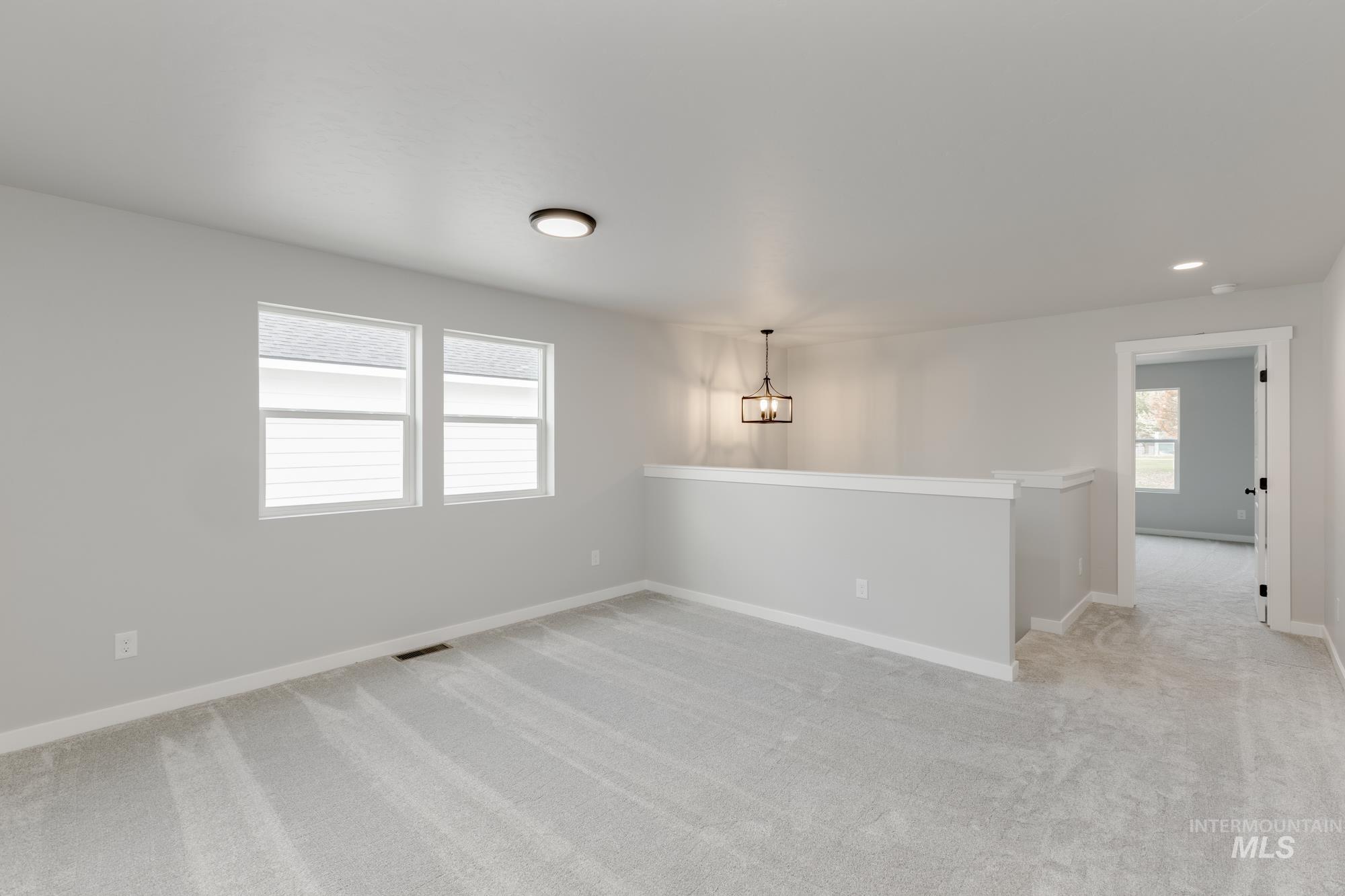 3672 West Dover Drive Meridian, ID 83642 - Photo 11 of 23 Unfurnished room with light carpet and a chandelier