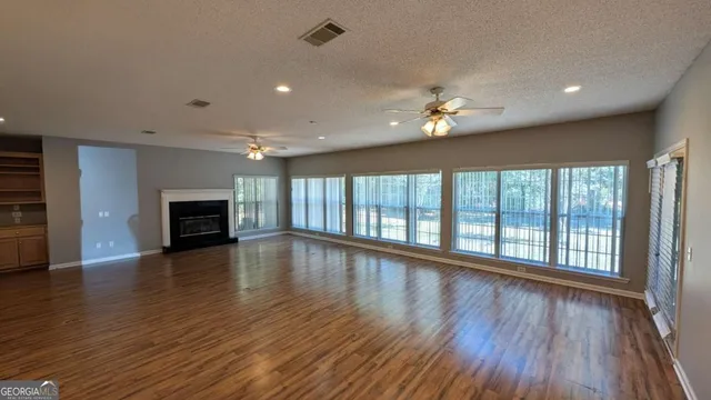 a view of empty room with wooden floor and fireplace