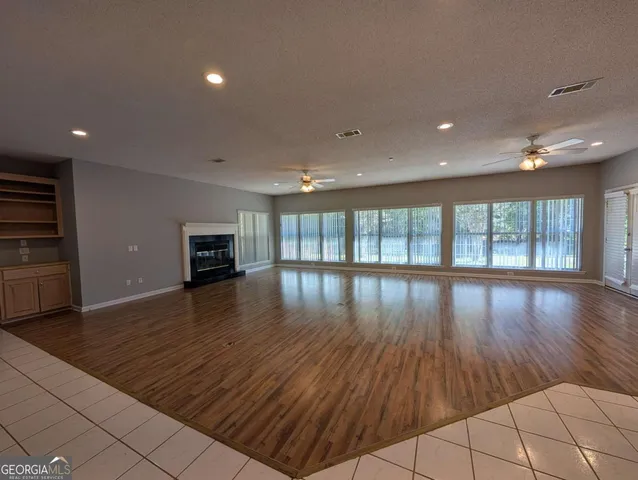a view of empty room with wooden floor and fireplace
