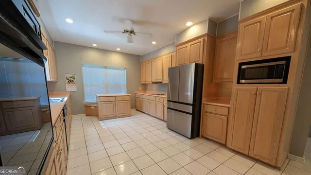 a kitchen with stainless steel appliances a refrigerator and a stove top oven
