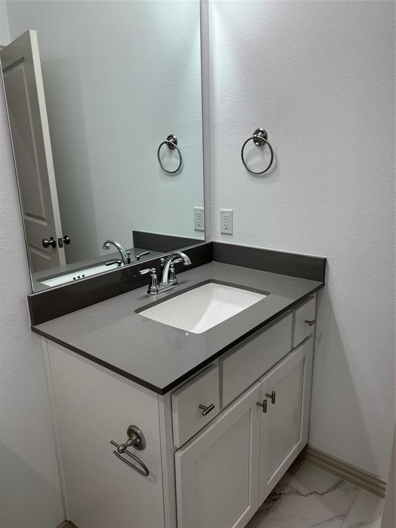 6041 Roper Road McKinney, TX 75070 - Photo 9 of 24 Modern vanity featuring a gray countertop, an integrated rectangular sink, and chrome-finish fixtures