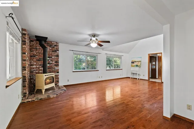 an empty room with a window and a ceiling fan