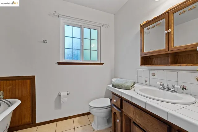 a view of an empty room with closet and a ceiling fan
