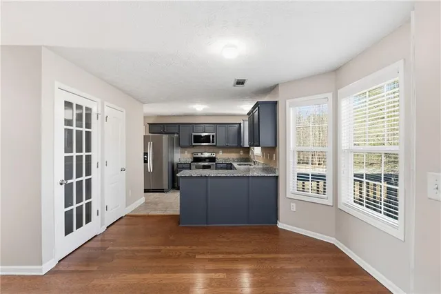 a kitchen with stainless steel appliances granite countertop a refrigerator and a stove top oven