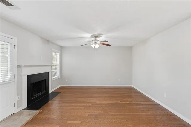 a view of an empty room with a fireplace and a window