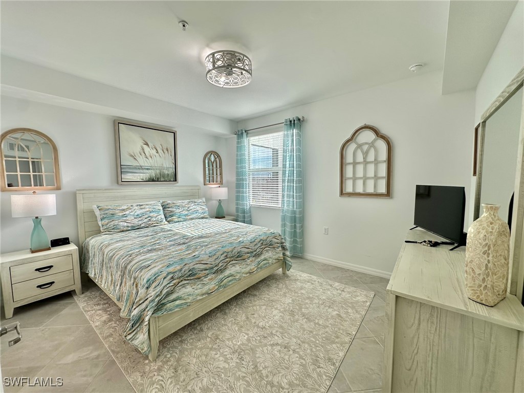 43989 Boardwalk Loop, Unit 2018 Coffeyville, KS 67337 - Photo 6 of 29 a bedroom with a bed and a flat screen tv